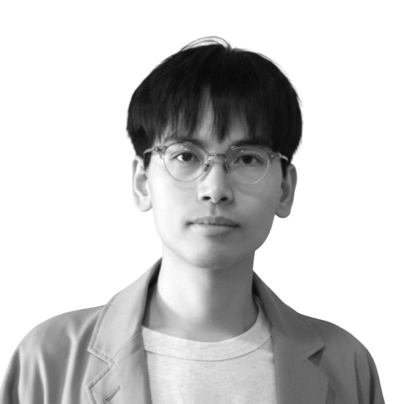 Portrait of a young person with short dark hair, round glasses, wearing a light jacket and shirt.