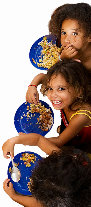 Girls at the school kitchen eating and smiling up to a camera